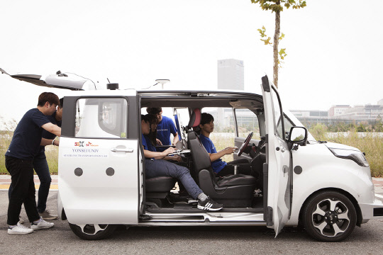 SK텔레콤과 연세대 김시호 교수 연구팀이 경차에 딥러닝을 활용한 자율주행 기술을 적용해 임시운행 허가를 취득했다. SK텔레콤과 연세대 연구원들이 자율주행차 장비를 점검하고 있다.  SK텔레콤 제공